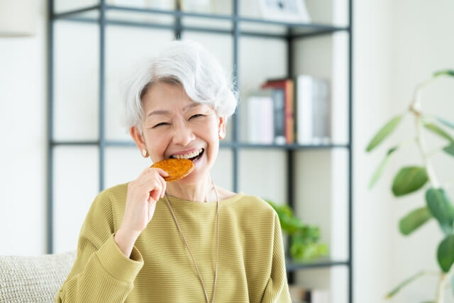 せんべいを食べるシニア女性