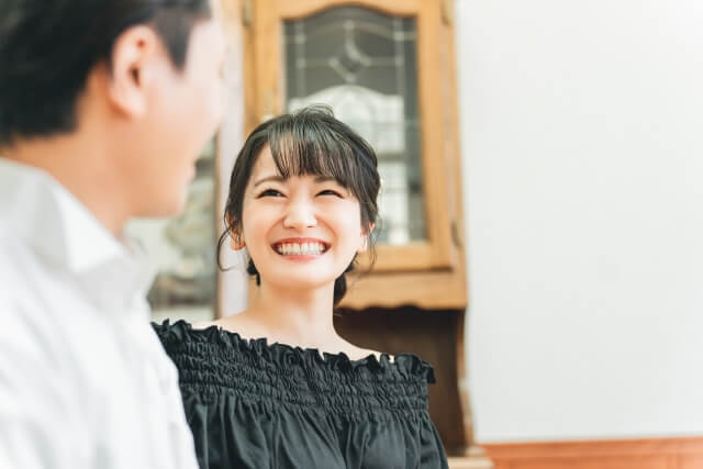 白い歯を見せて笑う笑顔の女性