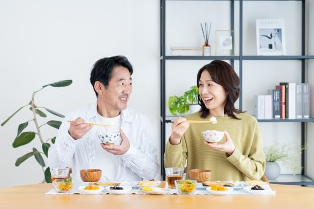 笑顔で食事をするミドル世代の夫婦
