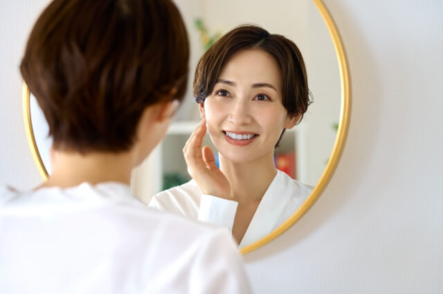 鏡を見て微笑む女性