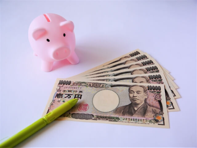 お札とピンクの豚の貯金箱