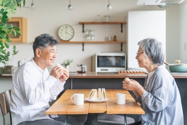 笑顔で食事をする中高年夫婦