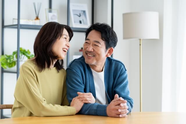 腕を組んで笑い合うミドル世代の夫婦