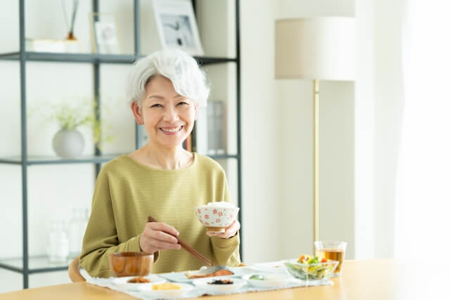笑顔で食事をするシニア女性